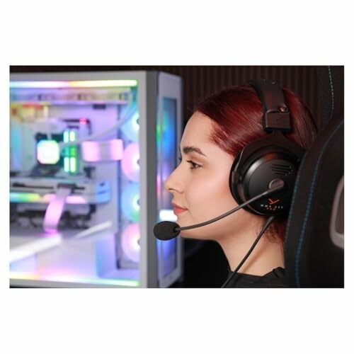 Woman wearing a headset in front of a colorful gaming PC.