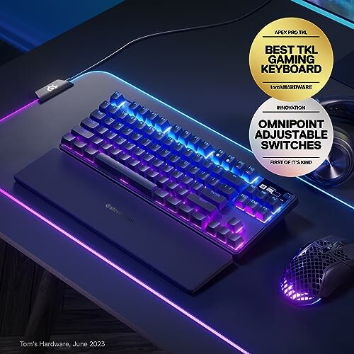 RGB gaming keyboard and mouse on a desk with award stickers.